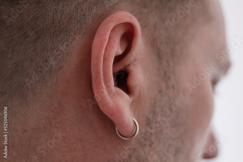 Fényképezés Earring in the ear, Close-up, Piercing in the ear Men