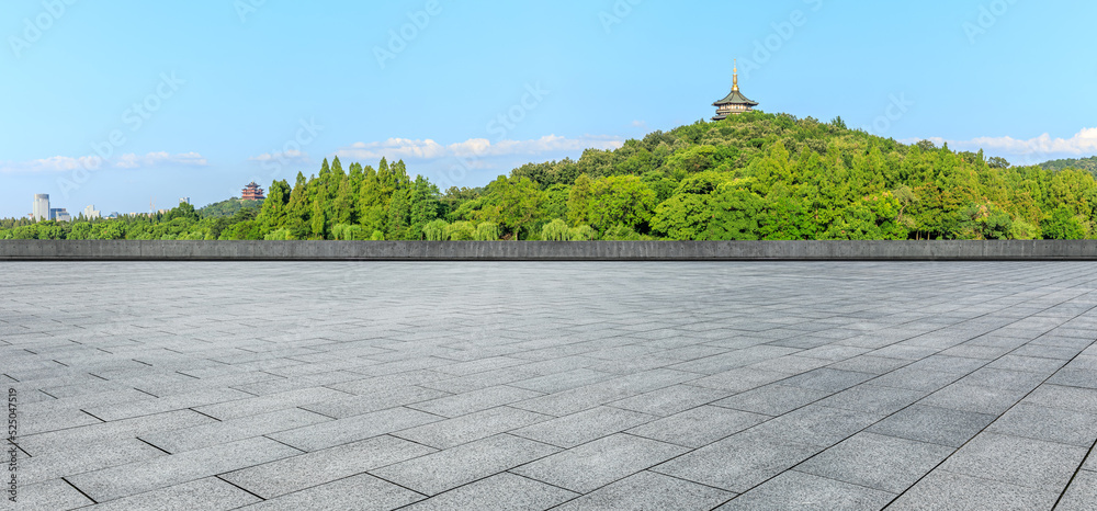 Empty square floor and green mountain with city skyline scenery in Hangzhou, China.