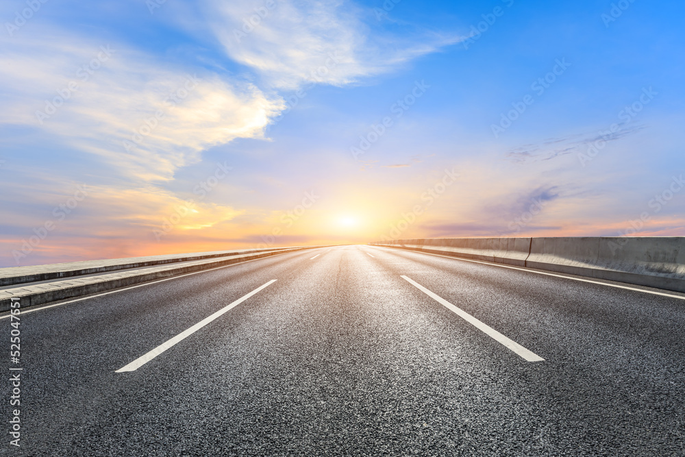 Asphalt road and sky clouds at sunrise. Road and sky background.