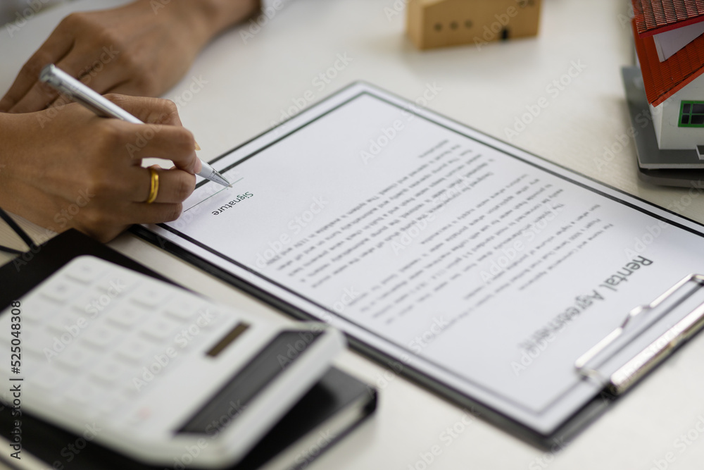 Businesswoman signing a legal real estate agreement. Businesswoman signing a legal real estate agreement.