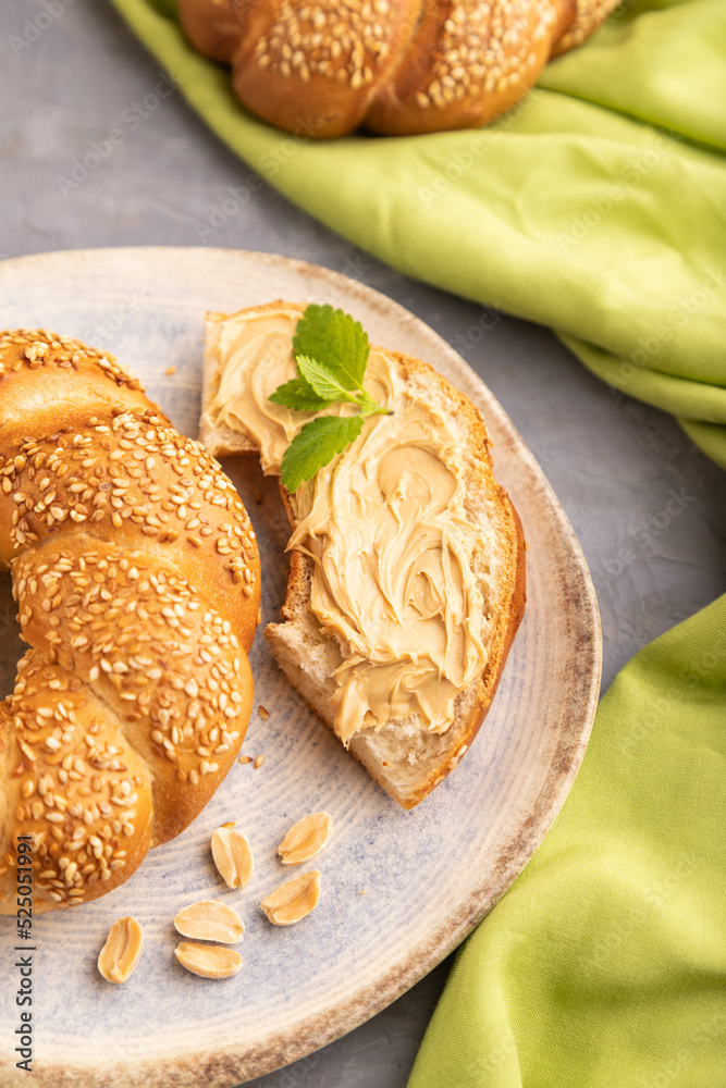 Φωτογραφία Homemade sweet bun with peanut butter and cup of coffee on a gray concrete