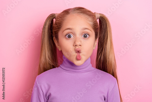 Photo of young adorable cute little girl make hilarious silly faces pout lips isolated on pink color background