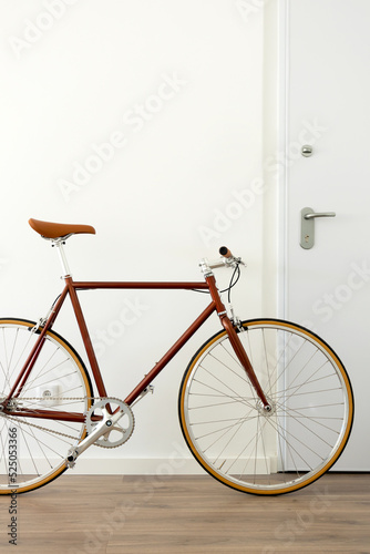Brown urban bicycle at apartment home  vertical
