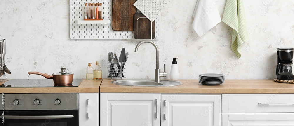Modern electric stove with sink and utensils in light kitchen Stock ...