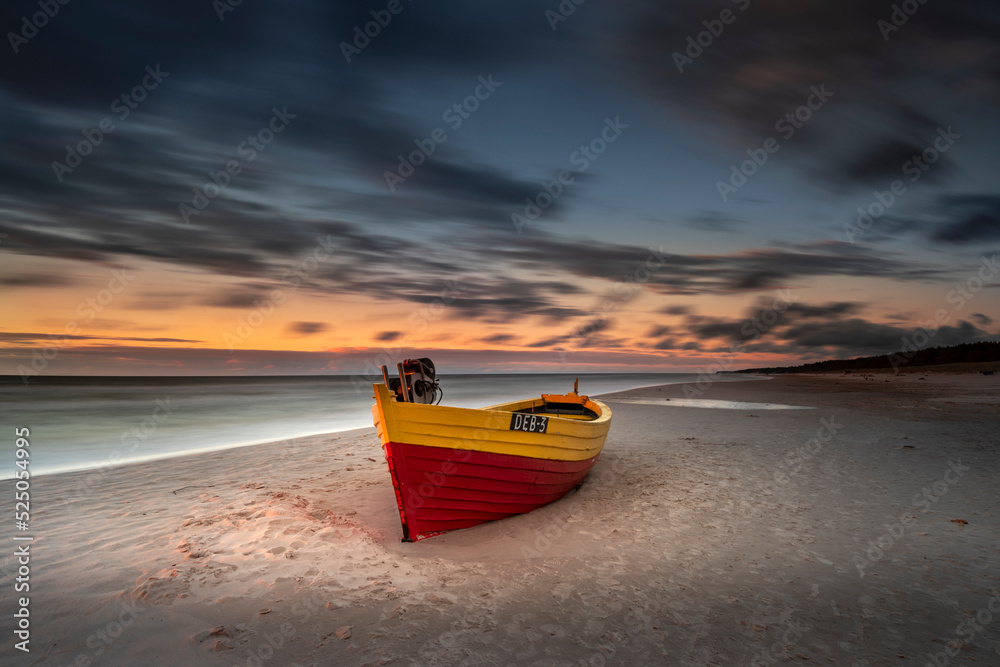 Obraz na płótnie Kuter rybacki - statek, na plaży w Dębkach o zachodzie słońca nad morzem bałtyckim z widokiem na plażę w salonie