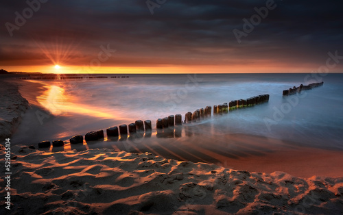 Morze bałtyckie. Plaża w miejscowości Chałupy - półwysep helski, piękny i kolorowy zachód słońca. Fale, piasek, wybrzeże, woda i falochron. Bałtyk