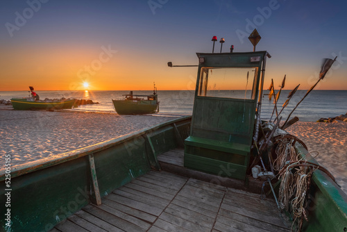 Kuter rybacki - statek, na plaży w Gdyni Orłowo o wschodzie słońca nad morzem bałtyckim z widokiem na plażę