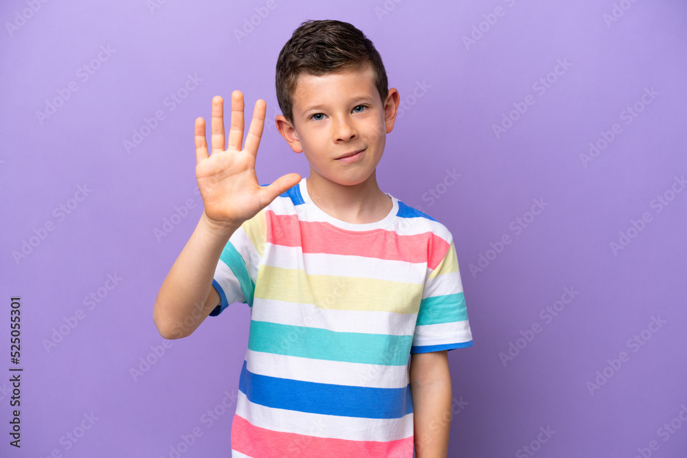 Little boy isolated on purple background counting five with fingers Little boy isolated on purple background counting five with fingers