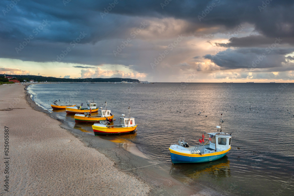 Cloudy sunrise on the beach of Baltic Sea in Sopot with fishing boats, Poland