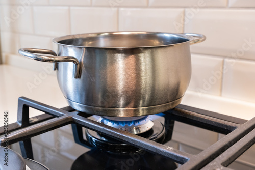 Saucepan is on the gas burner of the stove.