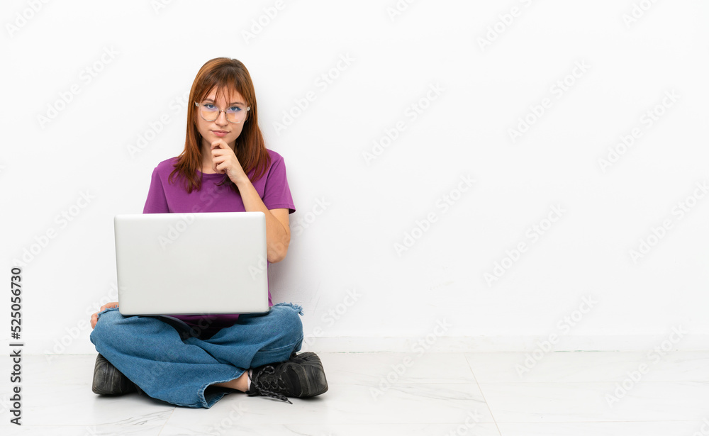 redhead girl with a laptop sitting on the floor thinking redhead girl with a laptop sitting on the floor thinking