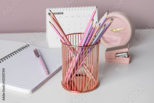 Metal cup with pencils on t...