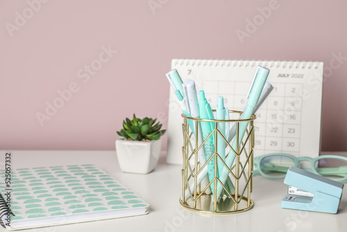 Golden cup with pens, noteb...