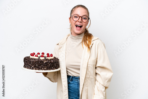 Young caucasian woman holding a Birthday cake isolated on white background with surprise facial expression