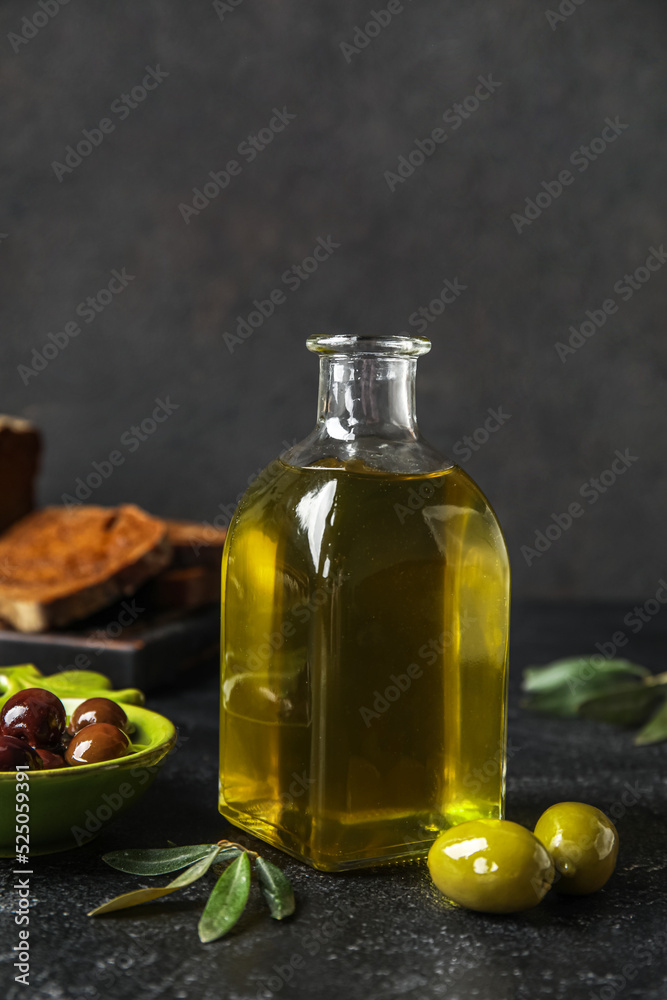 Bottle of fresh olive oil on dark background Bottle of fresh olive oil on dark background