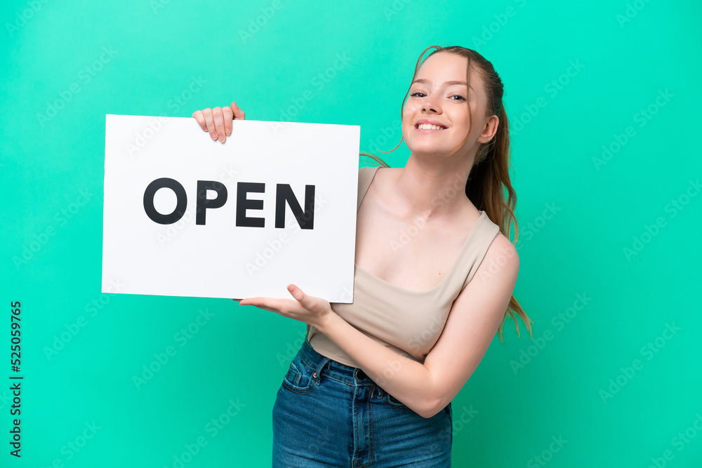 Young caucasian woman isolated on green background holding a placard with peace symbol with happy expression Young caucasian woman isolated on green background holding a placard with peace symbol with happy expression
