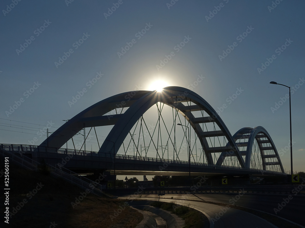 Silhouette of bridge with sun beams over it