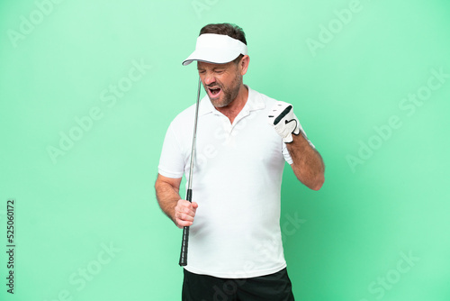 Middle age caucasian man isolated on green background playing golf and celebrating a victory