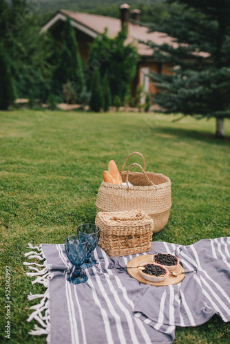 Fototapeta Naklejka Na Ścianę i Meble -  Beautiful romantic picnic with cake and two glasses of wine on the green meadow.