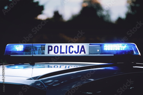 Emergency lights flashing on top of a Polish police ("Policja") patrol car