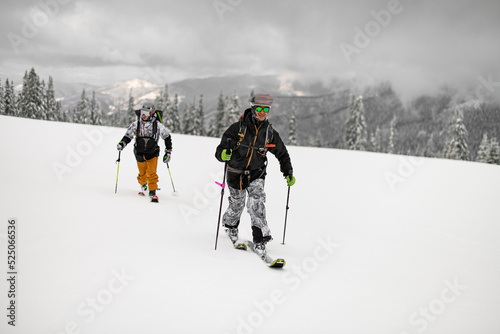 Two guys skiers with backpacks walking on ski. Ski touring.