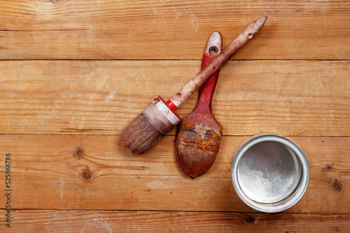 old paint brushes and an empty jar on the boards
