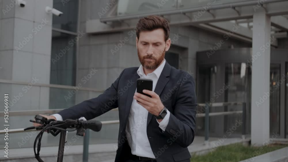 Caucasian Man in formal suit paying for scooter rent using mobile application, stand with smartphone waiting. People lifestyle, modern transportation, vehicle. Side view portrait. Success, business Caucasian Man in formal suit paying for scooter rent using mobile application, stand with smartphone waiting. People lifestyle, modern transportation, vehicle. Side view portrait. Success, business
