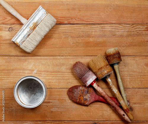 Old paint brushes and an empty can on boards
