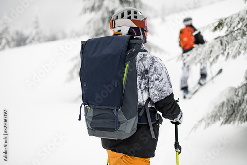 close-up of backpack on back of male skier in ski equipment at skitour photo