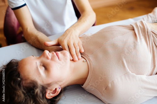 a beautiful girl lies on the table of an osteopath massage therapist and receives help
