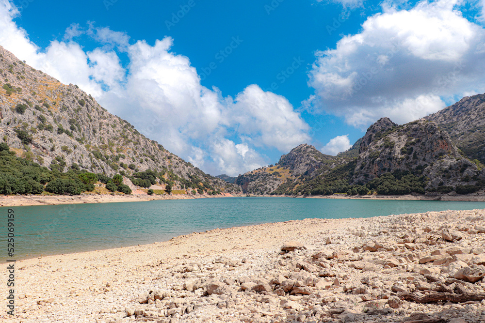 gor blau reservoir between the mountains of mallorca with a sky with clouds