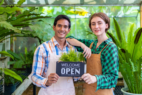 Canvas Print Team of diversity garden worker holding opening sign to welcome customer to thei