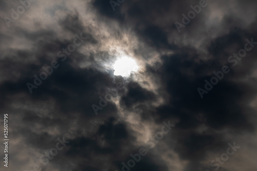 defocused the dark cloudy sky with gaps shining from the sun's light in the middle