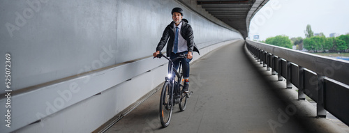 Tablou canvas Businessman commuter on the way to work, riding bike over bridge, sustainable lifestyle concept