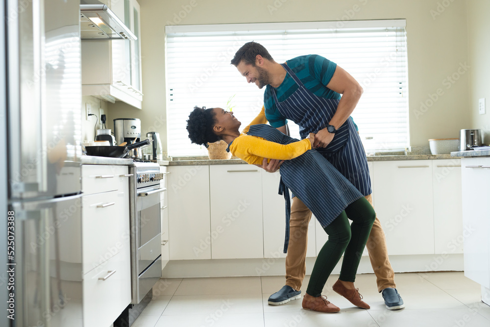 Image of happy diverse couple dancing in kitchen Image of happy diverse couple dancing in kitchen