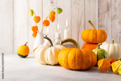 Autumn still life with pumpkins, flowers and candles on table.Thanksgiving da...