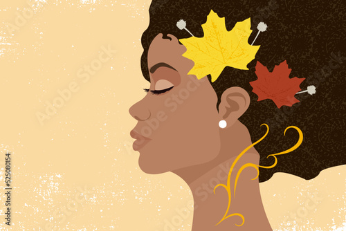 Profile view of an African woman's face on grunge background with fall leaves in her hair

