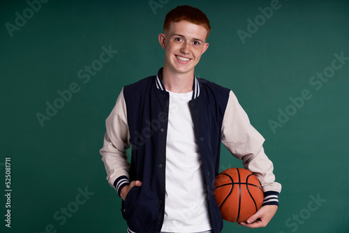 Slika na platnu Caucasian red head boy holding basketball ball and looking at camera
