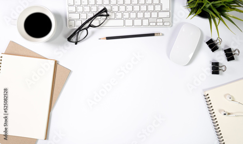 Flat lay of top view desk work table with computer notebook coffee and pencil work space in minimal white tone concept includes copyspace for add text or graphic