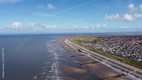 Aerial view of waves crashing onto the coast with views of buildings and houses in the distance. Taken in Cleveleys Lancashire England.  photo