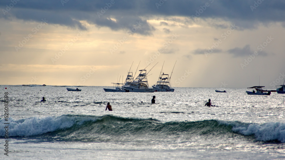 Surfers in silhouette off the beach in Tamarindo, Costa Rica