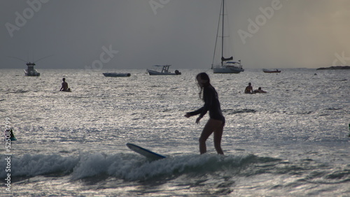 Silhoutte of a woman surfing off the beach Tamarindo, Costa Rica