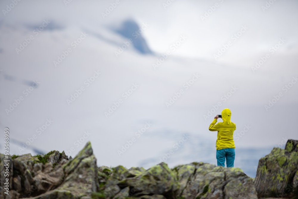 Obraz premium Young woman admiring the natural beauty of a glacier in the Swiss Alps. Europe