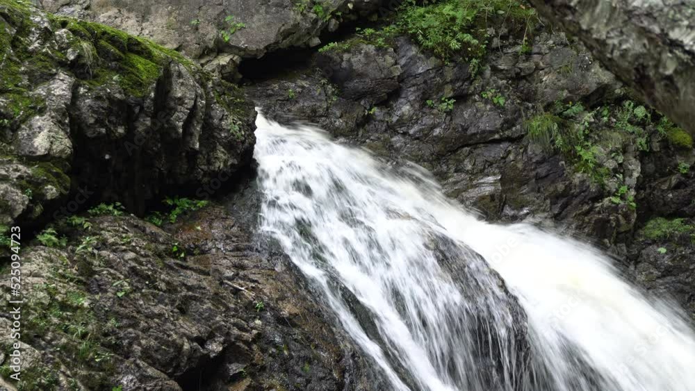 A powerful strong waterfall with a lot of rocks around, with some green vegetation. A powerful strong waterfall with a lot of rocks around, with some green vegetation.