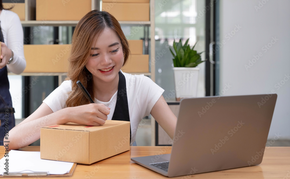 Portrait of Asian young woman SME working with a box at home the workplace.start-up small business owner, small business entrepreneur SME or freelance business online and delivery concept. Portrait of Asian young woman SME working with a box at home the workplace.start-up small business owner, small business entrepreneur SME or freelance business online and delivery concept.