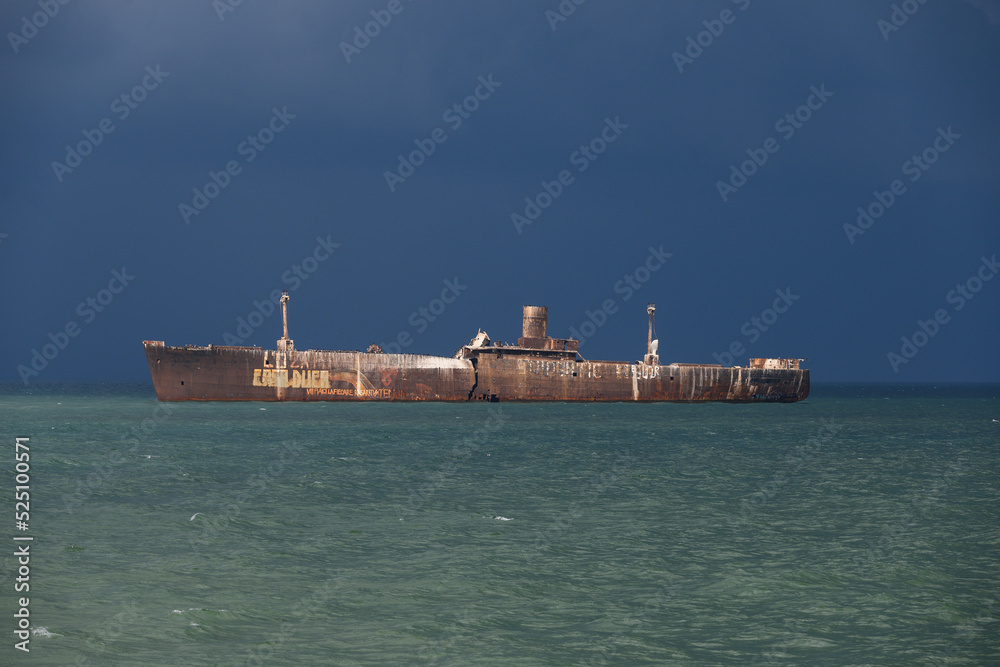 Rusty wreck of a ship. Wreck at sea. Black sky before the storm