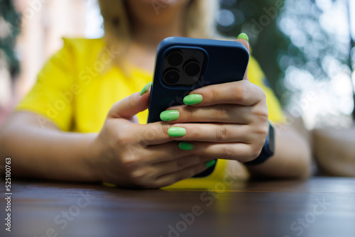 a girl sitting at a table holding a phone in her hands