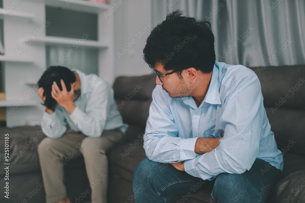 Homosexual male express sad or bad emotion from arguement or controversial problem. on sofas inside their homes, LGBTQ concept.