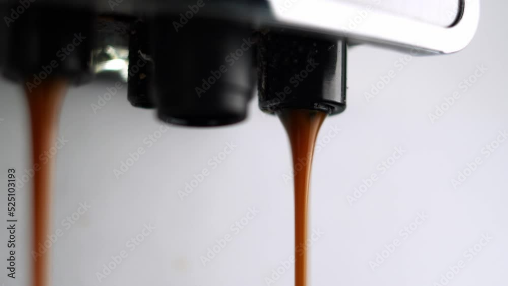 Close-up of espresso pouring from coffee machine. Making black coffee in automatic coffee machine Close-up of espresso pouring from coffee machine. Making black coffee in automatic coffee machine