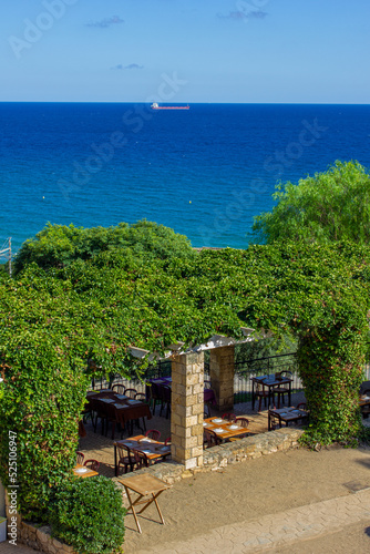 A bar restaurant on the shores of the Mediterranean sea or ocean, surrounded by a view and nature with which to eat relaxed with a feeling of calm and fullness